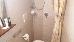 A small bathroom with a sink, toilet, and shower. - Stay in the heart of the historic center of Bari (Bari)