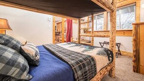 A rustic wooden bunk bed room with a blue bedspread and checkered pillows. - RMR: Tensleep A5 Condo in Teton Village (Teton Village)