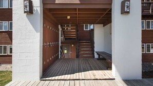 A wooden staircase leading to a building entrance with a bench at the bottom. - RMR: Tensleep A5 Condo in Teton Village (Teton Village)