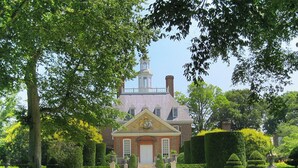 A stately building with a symmetrical facade, a central entrance, and a tower with a clock.