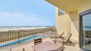 A balcony with a pool, beach view, and lounge chairs. - Gulf Coast Luxury Getaway on Orange Beach w/ Views (Orange Beach)
