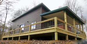 A log cabin with a wooden deck and large windows.