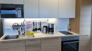 A modern kitchen with a built-in microwave, coffee maker, and oven.