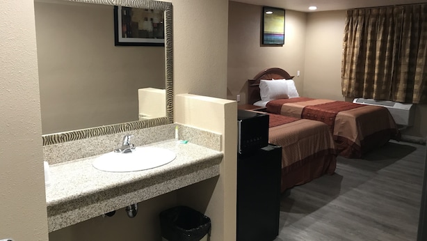 Ett hotellrum med badrum, säng, TV och värmeelement.