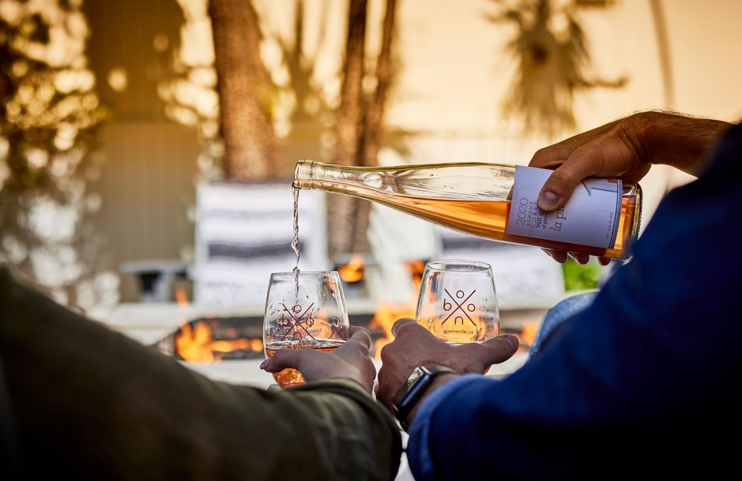 A person pouring a drink into a glass.
