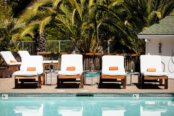 Alberca al aire libre, sombrillas en la alberca y camastros