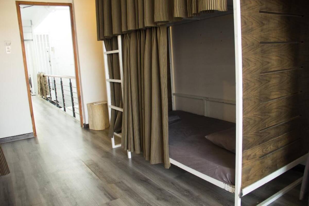 A bunk bed room with a wooden floor and a view of a balcony.