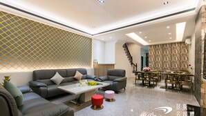 A modern living room with a sofa set, a coffee table, and a dining area with chairs and a table. - Play Inn (Dongshan)