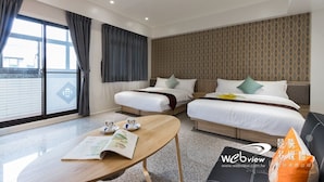 A hotel room with two beds, a wooden table with a book, and a large window with curtains. - Play Inn (Dongshan)