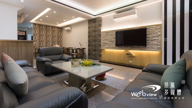 A modern living room with a stone accent wall, a flat-screen TV mounted above a wooden cabinet, and a seating area with sofas and a coffee table. - Play Inn (Dongshan)