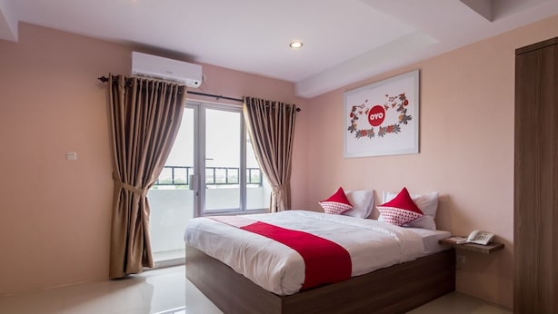 A hotel room with a large bed, a balcony, and a view of the outdoors. - Skyview Setiabudi Premium (Medan)