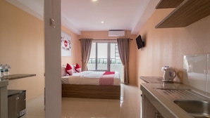 A hotel room with a bed, a kitchenette, and a bathroom. - Skyview Setiabudi Premium (Medan)