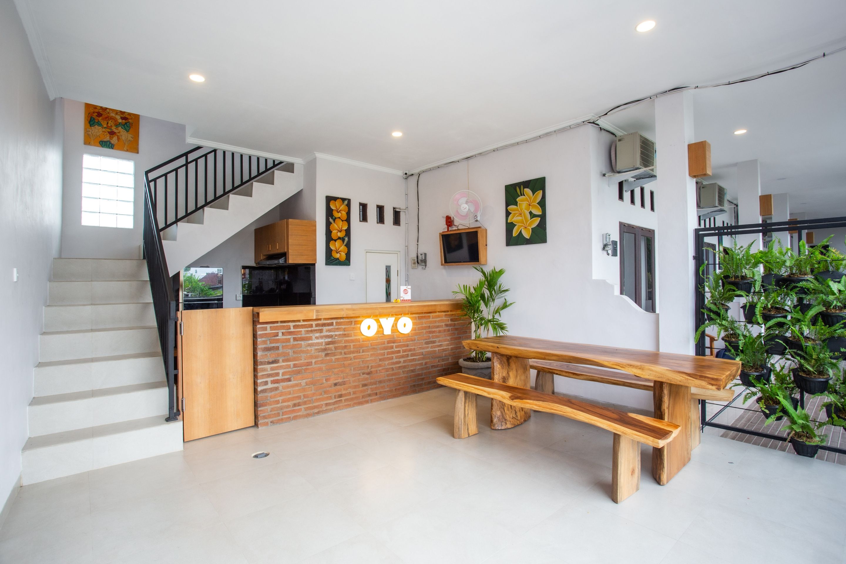 A modern kitchen with a wooden counter, a staircase, and a dining area with a wooden bench.