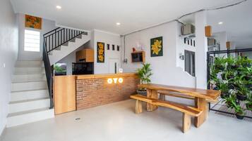 A modern kitchen with a wooden counter, a staircase, and a dining area with a wooden bench.