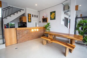 A modern kitchen with a wooden bench, a staircase, and a wall-mounted TV. - OYO 1207 Pondok 789 (Munggu)