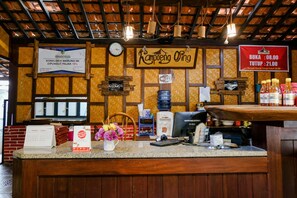 Ein Restauranttresen mit Holzdesign, ein Schild mit der Aufschrift 'Rampoeng Ong' und eine Speisekarte.