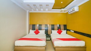A hotel room with two beds, a ceiling fan, and an air conditioning unit. - OYO 436 Emirates Suites (Bengaluru)