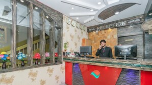 A reception area with a reception desk, a clock, and a sign that reads "RECEPTION". - OYO 436 Emirates Suites (Bengaluru)