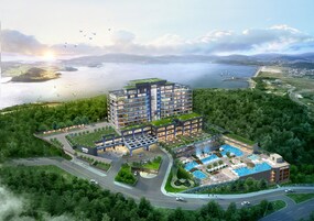 Un hotel moderno con varios pisos, una piscina en la azotea y vistas panorámicas al frente marítimo.