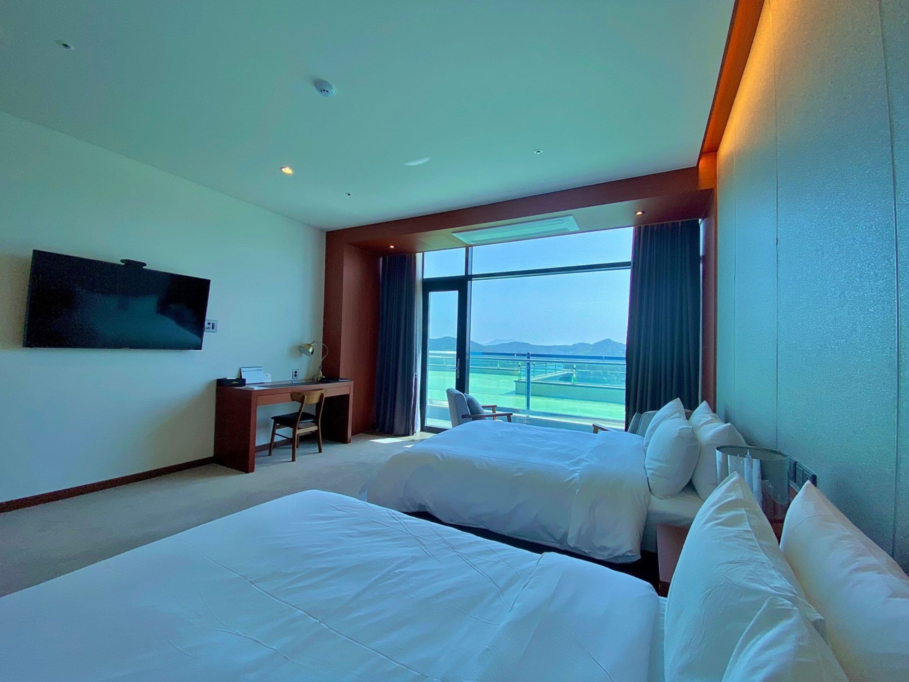 Een hotelkamer met twee bedden, een bureau en een televisie.