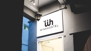 Hostellin sisäänkäynti, jossa on kyltti, jossa lukee: ”WINKHOSTEL”.