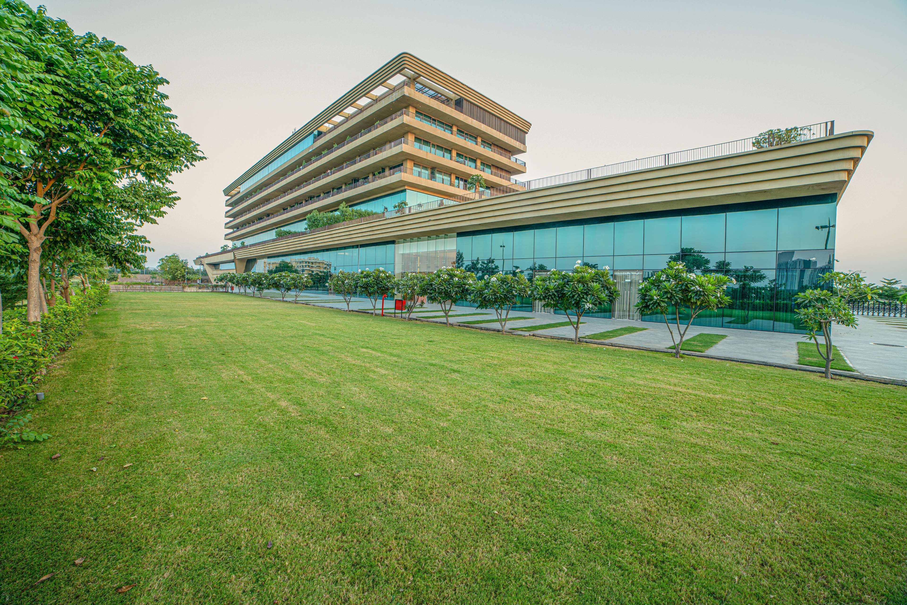 A modern multi-story building with a flat roof and large glass windows.
