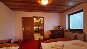 A room with a wooden ceiling, a bed with a red carpet, a wooden wardrobe, and a window with blinds. - Rooms and Apartments Panker (Moravske Toplice)