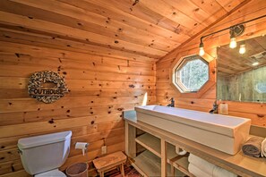 A wooden cabin bathroom with a white sink, a toilet, and a small step stool. - Blue Ridge Mtns Creekside Cabin w/ Hot Tub + Pier! (Blue Ridge)