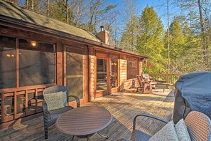 A wooden deck with outdoor furniture, a covered seating area, and a view of the surrounding forest. - Blue Ridge Mtns Creekside Cabin w/ Hot Tub + Pier! (Blue Ridge)