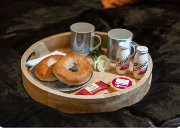 Enjoy a delicious breakfast setup with bagels, mugs, butter, and yogurt.
