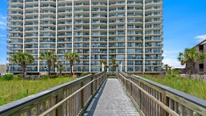 A multi-story hotel with a central walkway leading to the entrance.