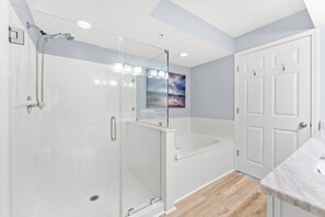 A modern bathroom with a glass-enclosed shower, a bathtub, and a white vanity with a marble countertop. - Large 4 Bedroom Oceanfront Condo in North Myrtle Beach! | Ashworth - 1601 (North Myrtle Beach)