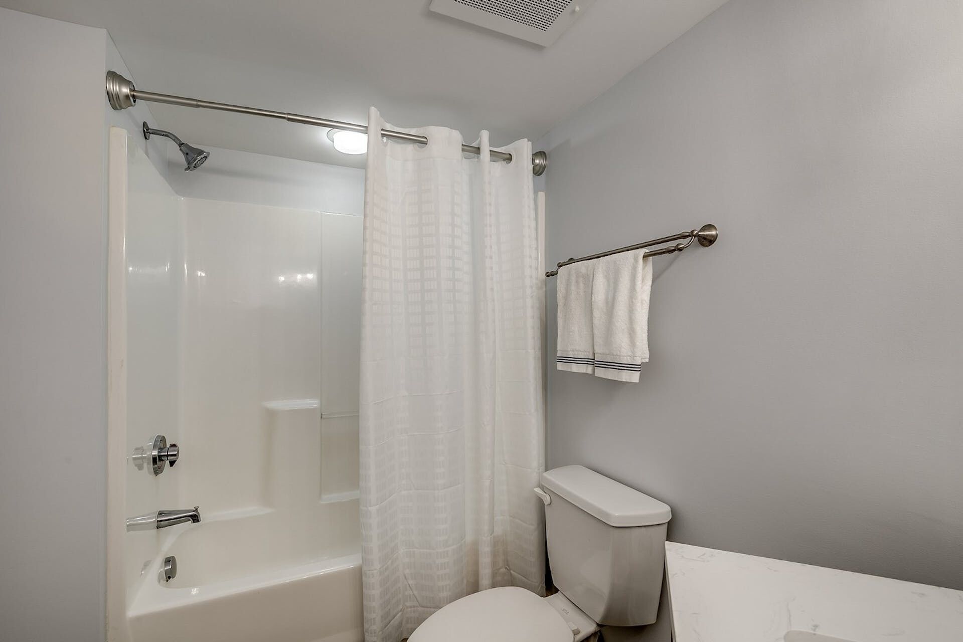 Un bagno con doccia vetro, un water e un porta asciugamani.