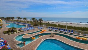 A pool area with multiple swimming pools, lounge chairs, and a beach view. - Cozy condo, full kitchen, 2-bedroom | Bay Watch Resort - 1632 (North Myrtle Beach)