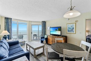 Relax in this spacious living area with a large sliding door leading to a balcony overlooking the ocean.