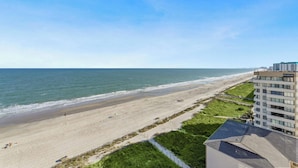 A beach view with a modern building adjacent to the shoreline. - Spacious 3 bedroom unit in Bluewater Keyes | Bluewater Keyes - 1105 (North Myrtle Beach)