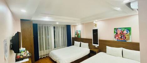 Habitación de hotel con dos camas, un escritorio de madera, un televisor y un cuadro en la pared.