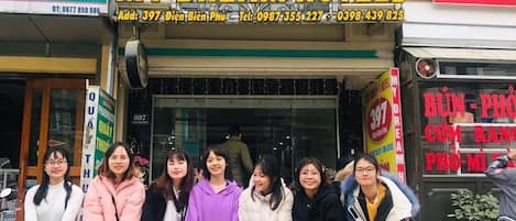 Un grupo de personas frente a un hotel con varias maletas.