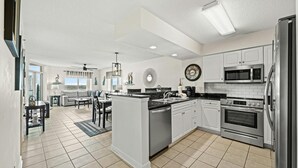 Una cocina moderna con armarios blancos, electrodomésticos de acero inoxidable y una isla central.