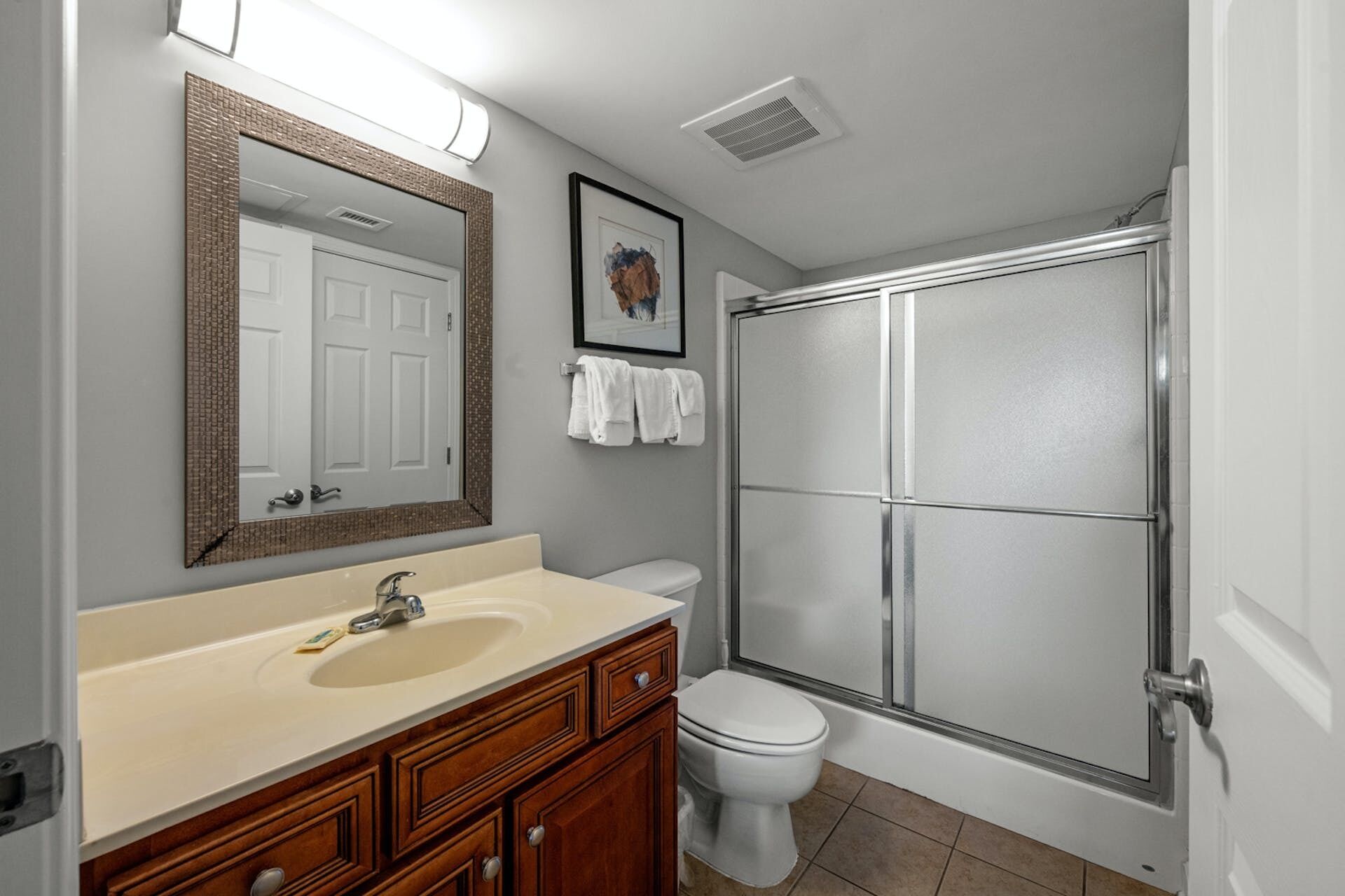 Une salle de bain avec un lavabo, des toilettes et une douche.