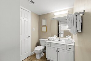 Un baño moderno con inodoro, lavamanos y espejo.