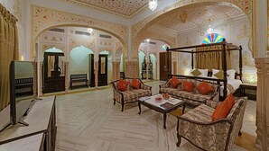 A luxurious room with ornate ceiling and walls, a four-poster bed, and classic furniture. - The Jaibagh Palace (Amer)