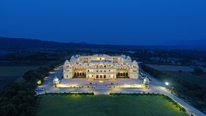 A large, multi-story building with a symmetrical facade, multiple domes, and a central courtyard. - The Jaibagh Palace (Amer)