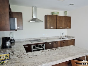 Deluxe Condo, Bay View | Private kitchen | Full-size fridge, microwave, stovetop, cookware/dishes/utensils