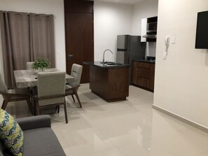 Condo Deluxe, vista parcial al océano | Área de sala de estar | Televisión de pantalla plana 