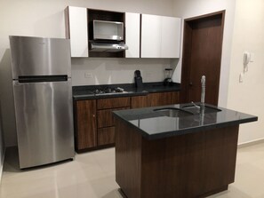 Condo Deluxe, vista parcial al océano | Cocina privada | Refrigerador con congelador, microondas y parrilla de estufa 