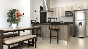 Apartamento Deluxe | Cocina privada | Frigorífico grande, microondas, trona infantil y utensilios de cocina