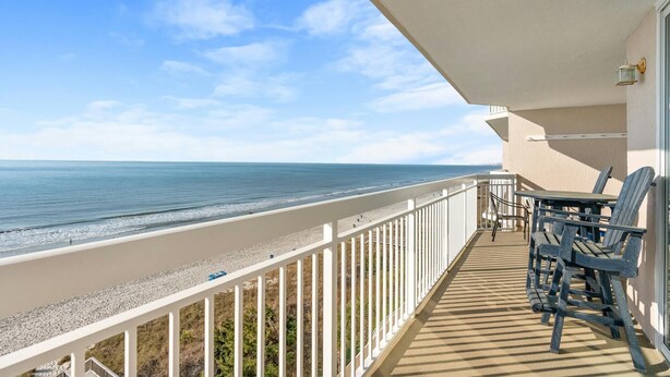 Ein Balkon mit Blick auf Strand und Meer.