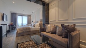 Habitación Deluxe, balcón, vistas al mar | Minibar, caja fuerte, escritorio y espacio para trabajar con un portátil