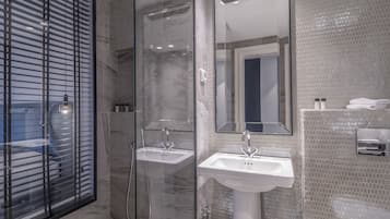 Ein modernes Badezimmer mit einer Duschkabine, zwei Waschbecken und einem großen Spiegel.